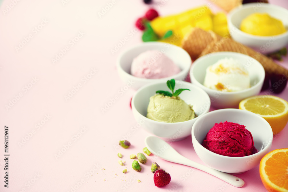Red, pink, yellow, green, white ice cream balls in bowls, waffle cones, berries, orange, mango, lemon, mint, pistachio, pink shabby chic background. Ice-cream colorful collection, summer concept Red, pink, yellow, green, white ice cream balls in bowls, waffle cones, berries, orange, mango, lemon, mint, pistachio, pink shabby chic background. Ice-cream colorful collection, summer concept