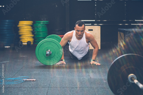 Tableau sur toile Man doing burpees over the bar