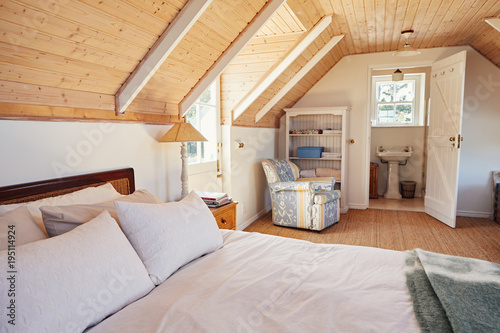 Spacious attic bedroom with bathroom in a home photo