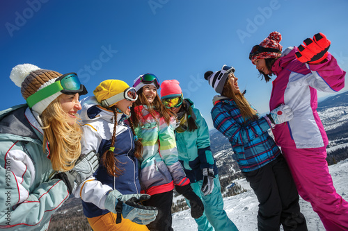 Group of friends snowboarders having fun on the top of mountain