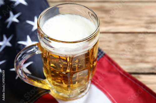 Glass of beer and American flag on table