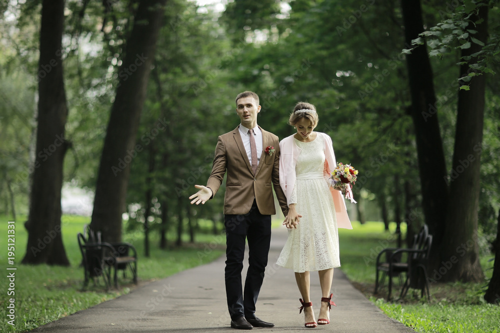 Newlyweds groom and bride walking in autumn park Newlyweds groom and bride walking in autumn park