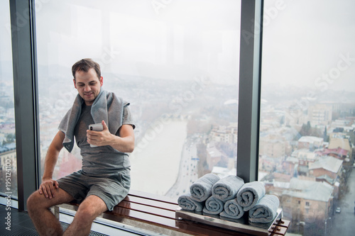 Canvas Print Handsome man taking a selfie with mobile phone after indoors training