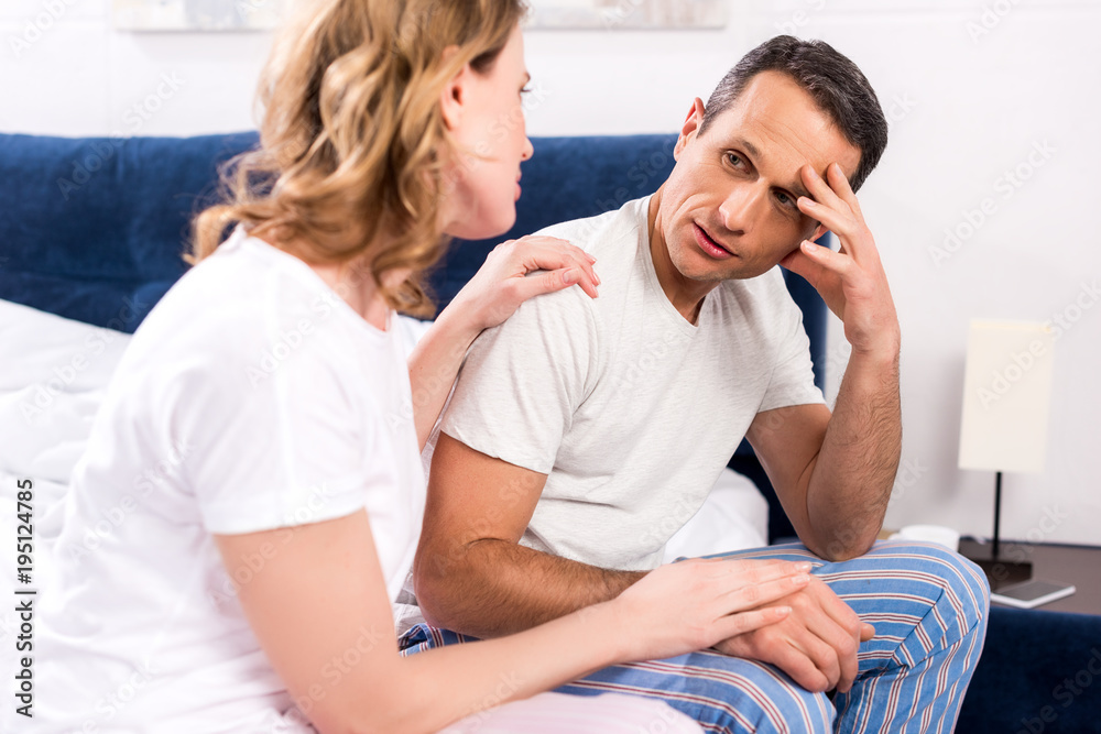 Obraz premium woman cheering up upset husband at home