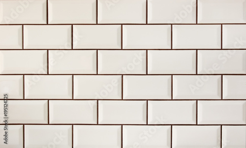 White metro tiles patterned wall. Beige ceramic brick tiles background.