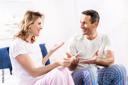 portrait of happy wife with pregnancy test and husband at home