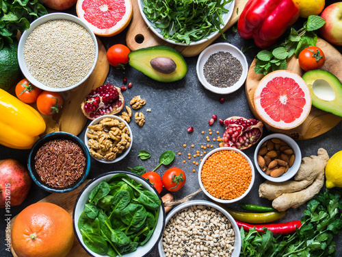 Fresh raw ingredients for healthy cooking. Vegetables, fruit, seeds, cereals, beans, spices, superfoods, herbs. Top view. Diet or vegetarian food concept. Copy space