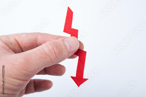 Red arrow in hand, as a symbol of financial fall. photo