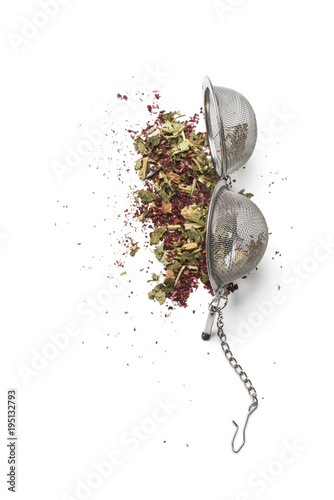 tea infuser opened on white table with herbal mixture for tea. photo