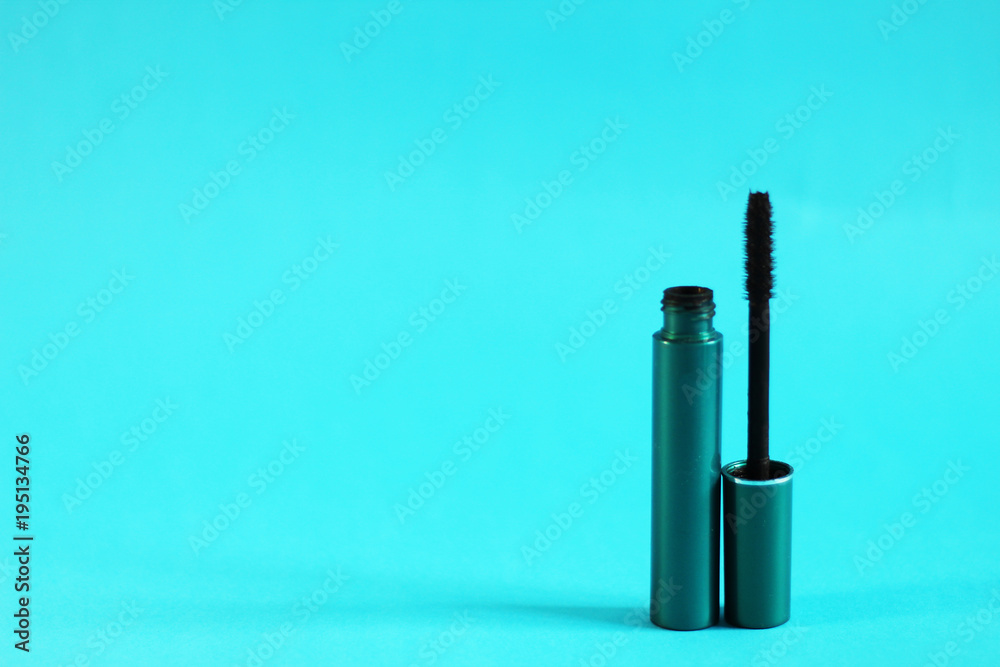 Mascara, open bottle and the brush, blue background, free copy space Mascara, open bottle and the brush, blue background, free copy space