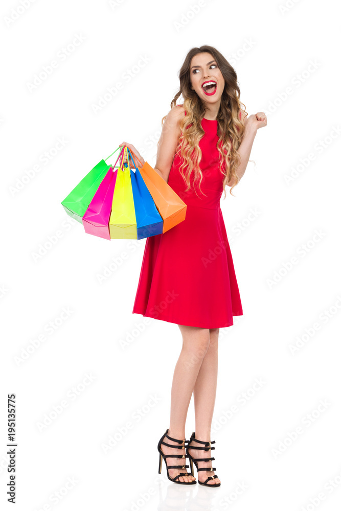 Happy Woman In Red Dress With Colorful Shopping Bags Is Shouting And Looking Away