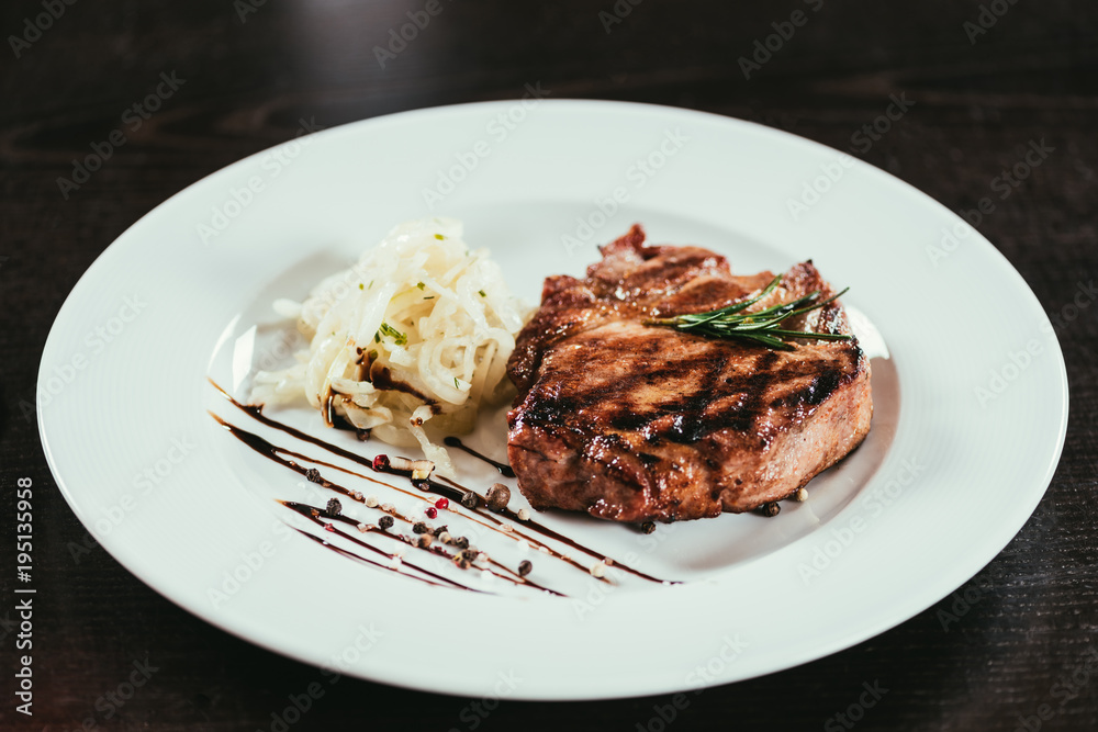 delicious grilled juicy steak with rosemary and sauce on plate delicious grilled juicy steak with rosemary and sauce on plate