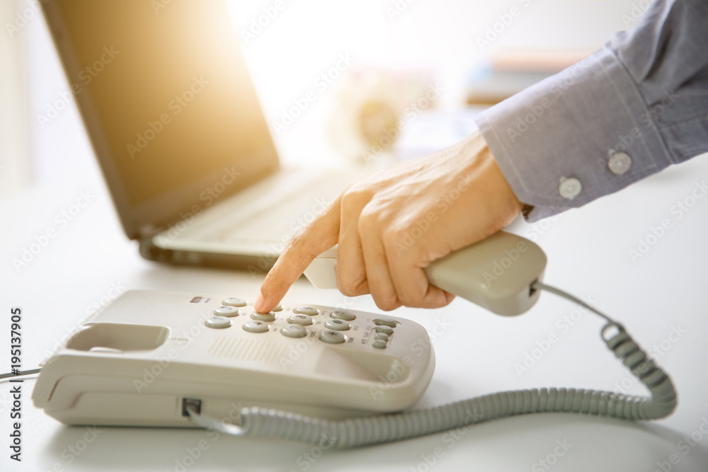 businessman dial digital telephone with office background businessman dial digital telephone with office background