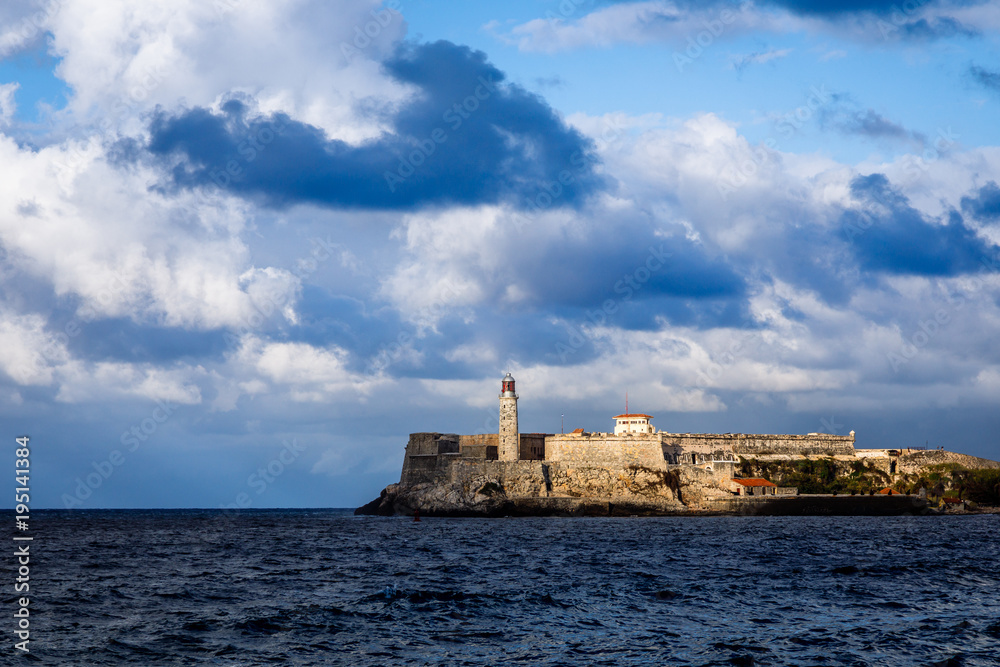 El Morro spanish fortress walls with lighthouse with sea in the foreground and clouds above, Havana, Cuba