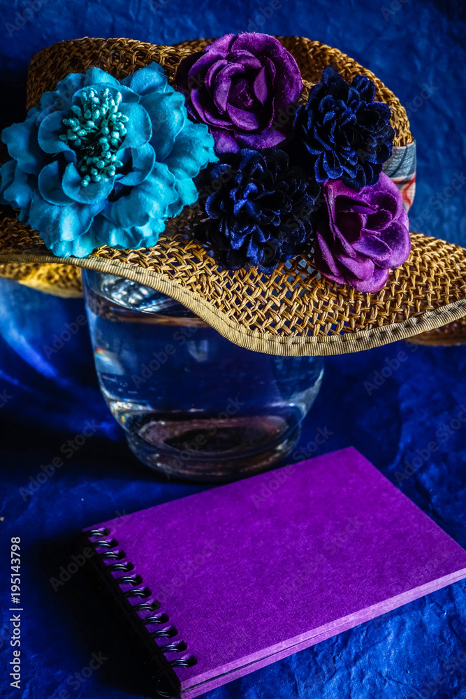 straw hat with artificial flowers in vintage style  and purple album