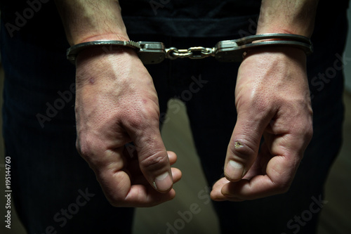 The arrested criminal handcuffed. Hands with handcuffs in the front