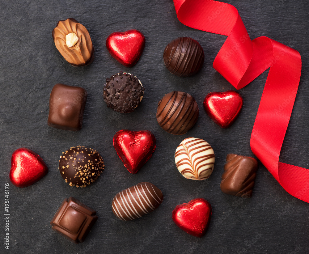 Various chocolate candies and a red ribbon Various chocolate candies and a red ribbon