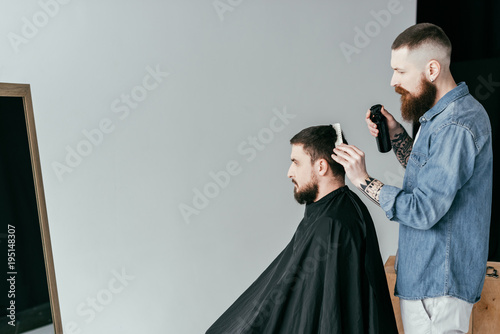 side view of barber cutting hair at barbershop isolated on white