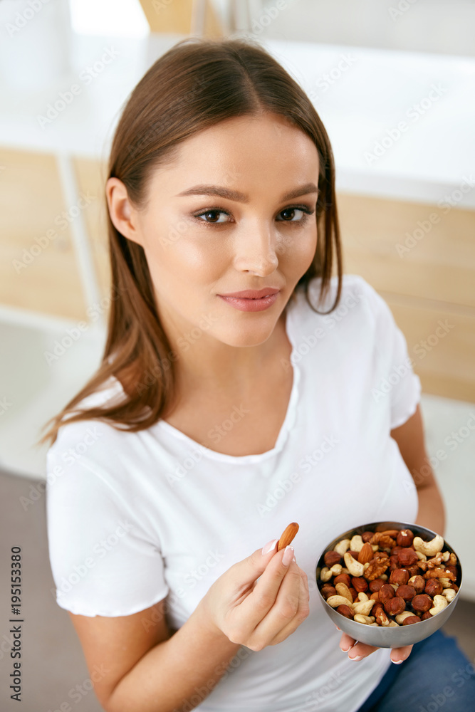 Healthy Food. Happy Woman Eating Nuts Healthy Food. Happy Woman Eating Nuts
