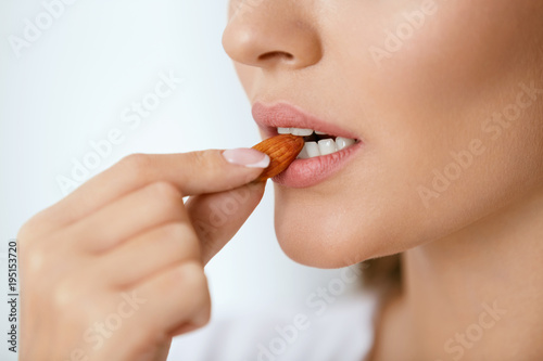 Woman Eating Nuts. Closeup Of Female Mouth Biting Nut.