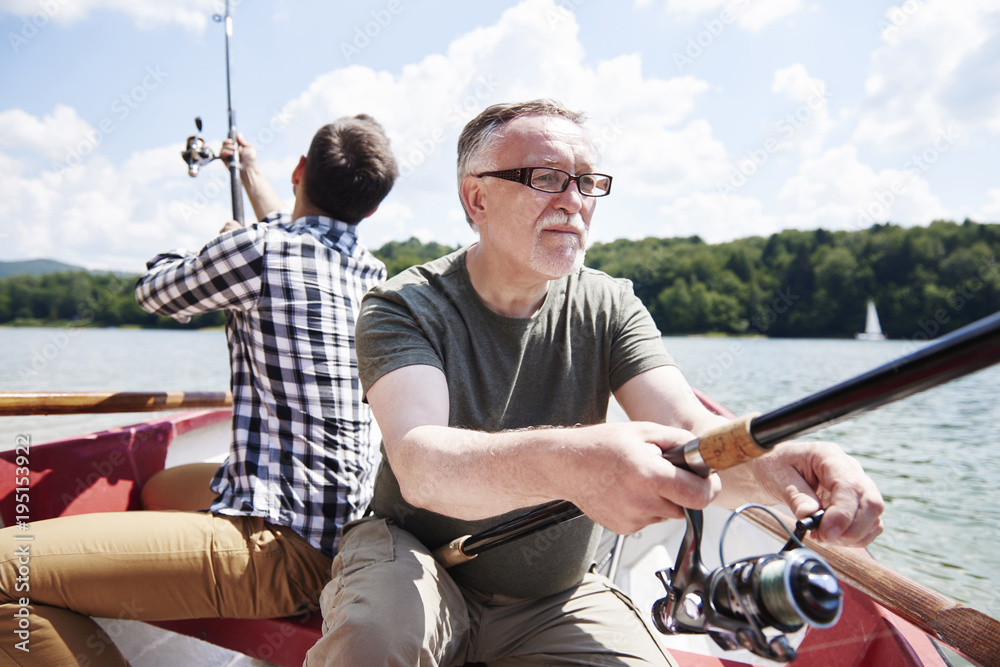 Obraz premium Male friendship with fishing rod on the rowboat