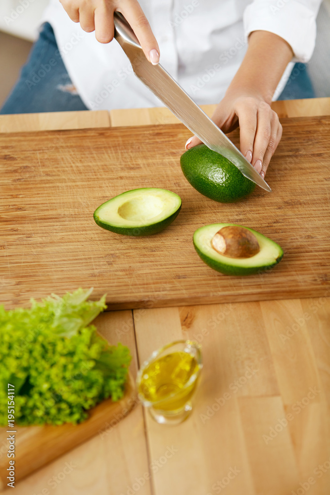 Diet. Female Hands Cutting Avocado In Kitchen.