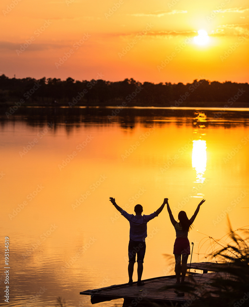 Fototapeta premium silhouette of woman and man, couple lover holding hand on the beach when the sun is rising