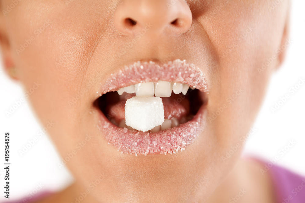 Fototapeta premium Female lips with sugar biting cube