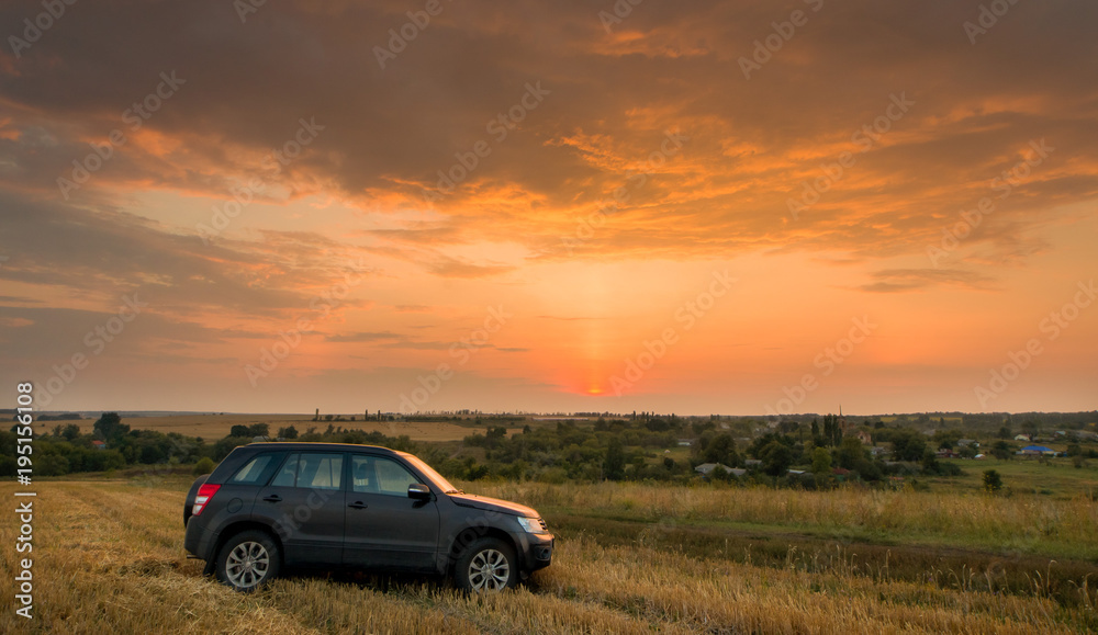 Road car on a field at sunset