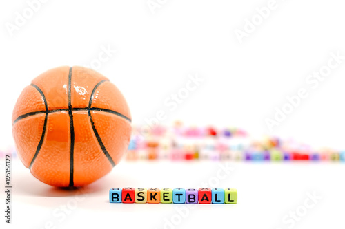 BASKETBALL word from alphabet letter beads and blurred colourful cubes on white background for sport and exercise concept