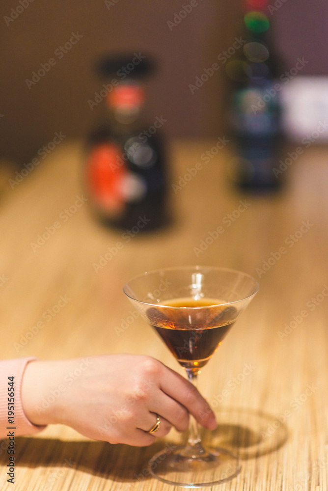 women's hand holds a glass of liquor