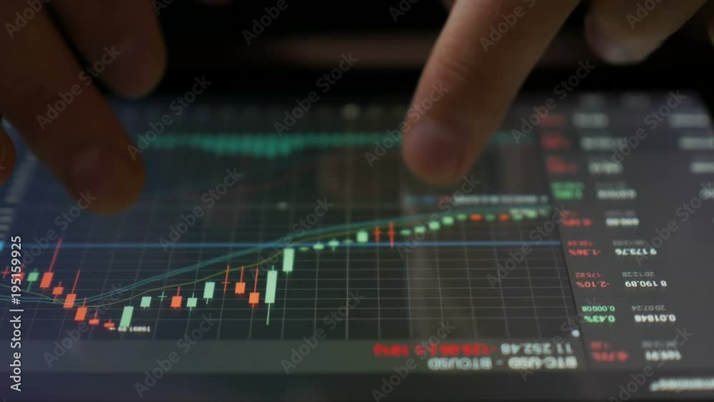 Stock market, trading online, trader working with tablet on stockmarket trading floor. Man touching screen, browse foreign exchange market data, chart. Forex. Crypto currency. Bitcoin cryptocurrency.