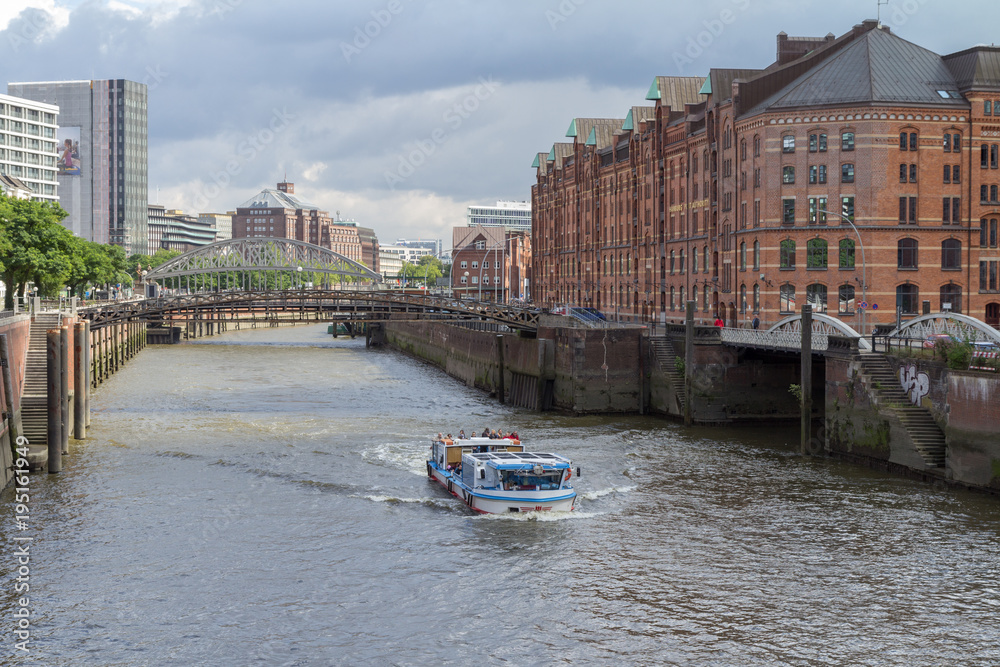 Obraz premium Boat in a canal with bridge in Speicherstadt hamburg