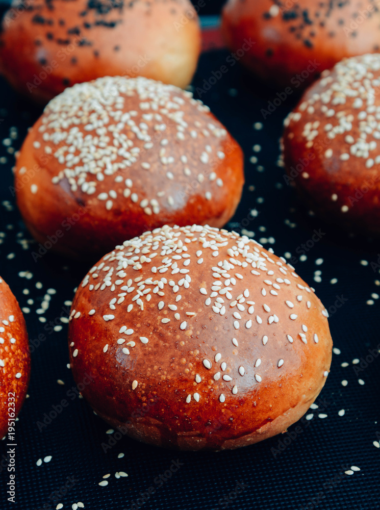 Yeast buns before baking, lie on baking sheet with baking paper. Round buns are smeared with egg. Cooking process Yeast buns before baking, lie on baking sheet with baking paper. Round buns are smeared with egg. Cooking process