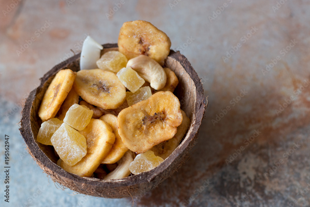 candied fruits, cashews and dried bananas in coconut shell candied fruits, cashews and dried bananas in coconut shell
