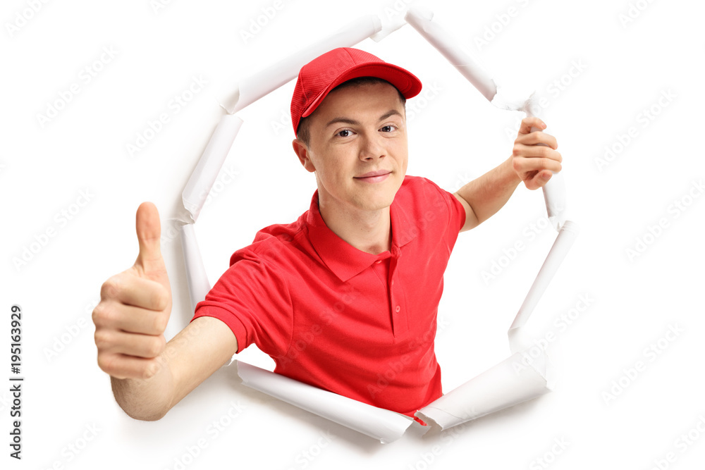 Teenage delivery boy breaking through paper Teenage delivery boy breaking through paper