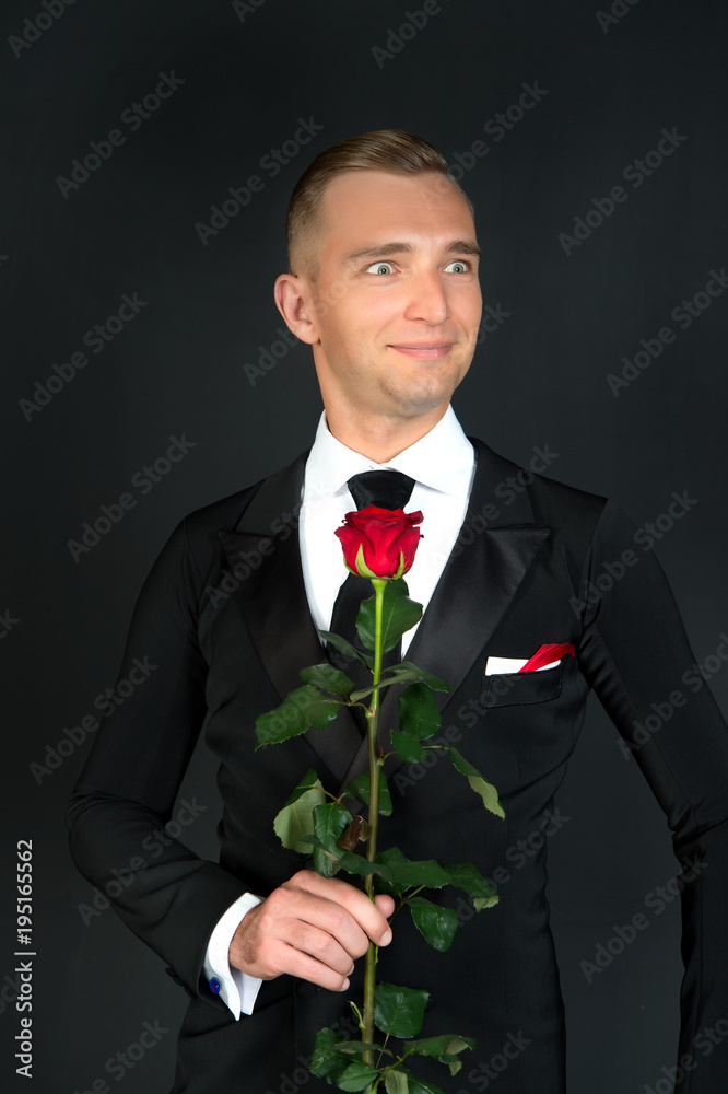 Ballroom dancer smile with red rose on dark background Ballroom dancer smile with red rose on dark background