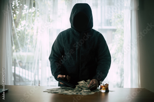Photography Hooded criminal gun shooting with dollar