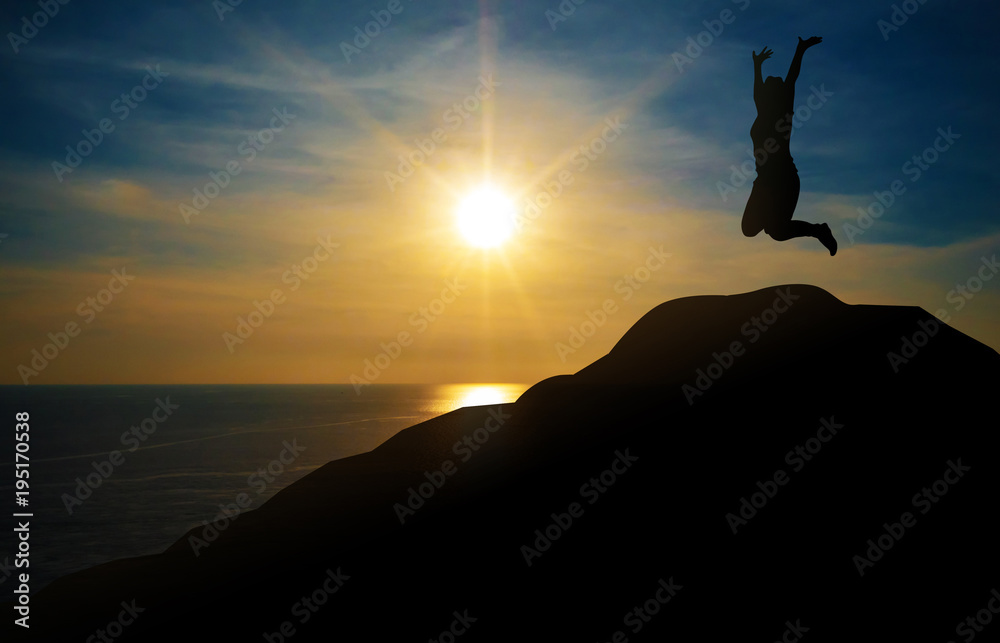 Silhouette of young woman jumping on top mountain. Evening sunset lighting and blue sky background. Concept happy celebration and successful