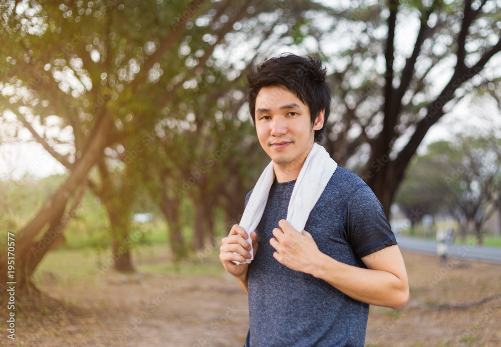young sporty man with white towel resting after workout sport exercises outdoors at park young sporty man with white towel resting after workout sport exercises outdoors at park