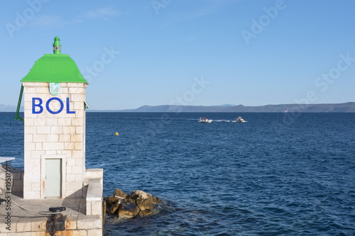 Lighthouse on the pier at the entrance to the port of Bol city on the Brac island in Croatia
