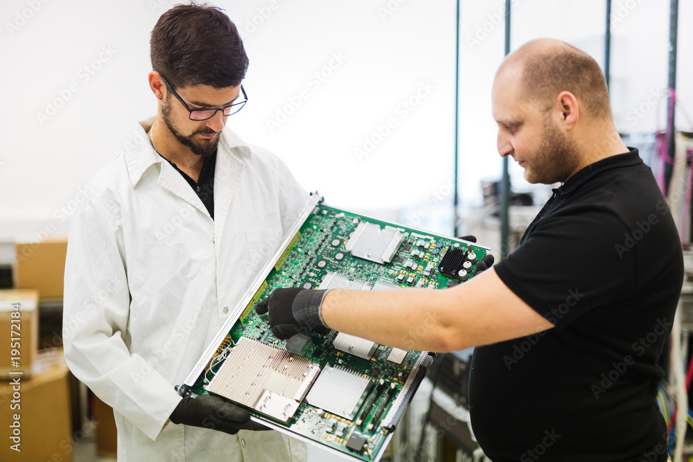 Portrait of young engineer holding CMTS card