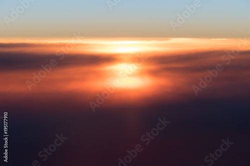Beautiful sunset or sunrise above clouds from airplane perspective © Aleksei