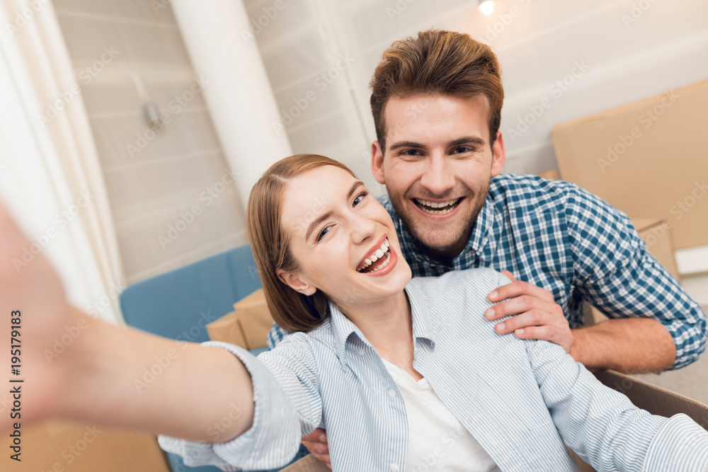 A young couple makes selfie while moving to a new apartment. Moving newlyweds to new housing. A young couple makes selfie while moving to a new apartment. Moving newlyweds to new housing.