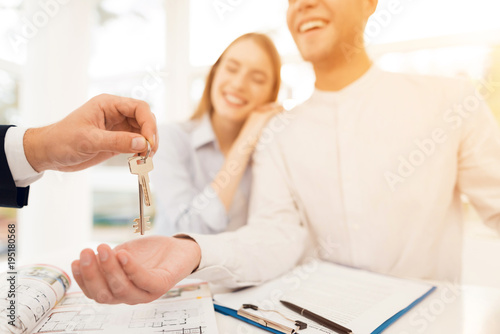 Young couple in a meeting with a realtor. Guy and girl make a contract with realtor buying property. photo