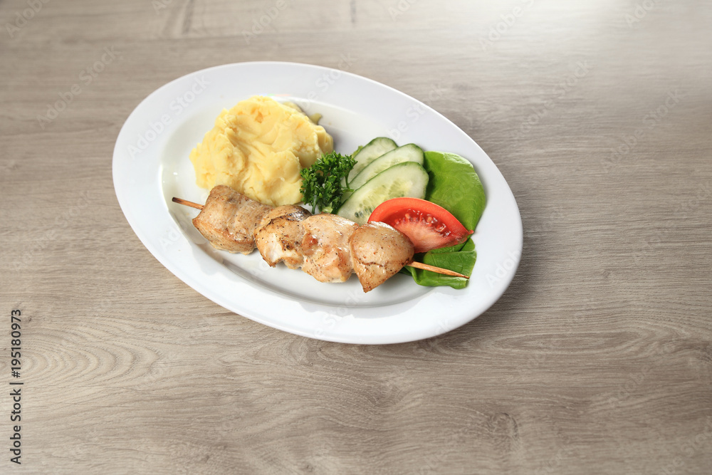 kebab with side dish and vegetables on the table kebab with side dish and vegetables on the table