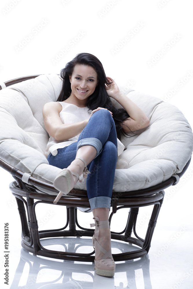 Modern young woman relaxing in a round cozy soft chair Modern young woman relaxing in a round cozy soft chair