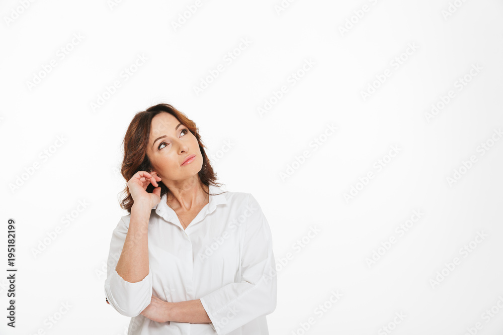Photo of mature woman 40s in white clothing looking upward on copyspace, isolated over blanc background in studio Photo of mature woman 40s in white clothing looking upward on copyspace, isolated over blanc background in studio