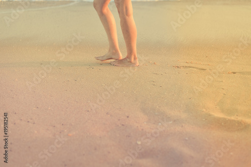 Closeup on female legs by the beach shore outdoors tranquil nature background. Active person walking by coastline, healthy beauty free leisure aspiration lifestyle scene