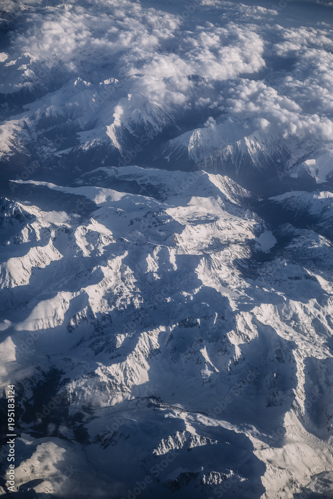 Fototapeta premium Snowy mountains and clouds aerial view